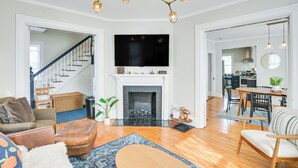 Un salón espacioso con chimenea, televisor y comedor con mesa y sillas.
