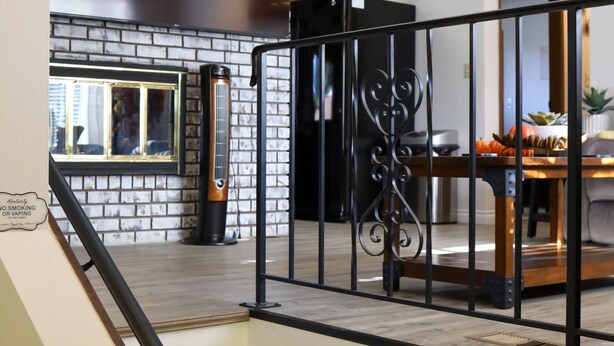 Un interior moderno con una escalera, una pared de ladrillo y un área de comedor.