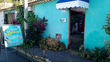 Un petit bâtiment turquoise, doté d’une marquise bleue et d’une enseigne publicitaire indiquant qu’il s’agit d’un commerce.