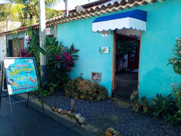Un petit bâtiment turquoise, doté d’une marquise bleue et d’une enseigne publicitaire indiquant qu’il s’agit d’un commerce.