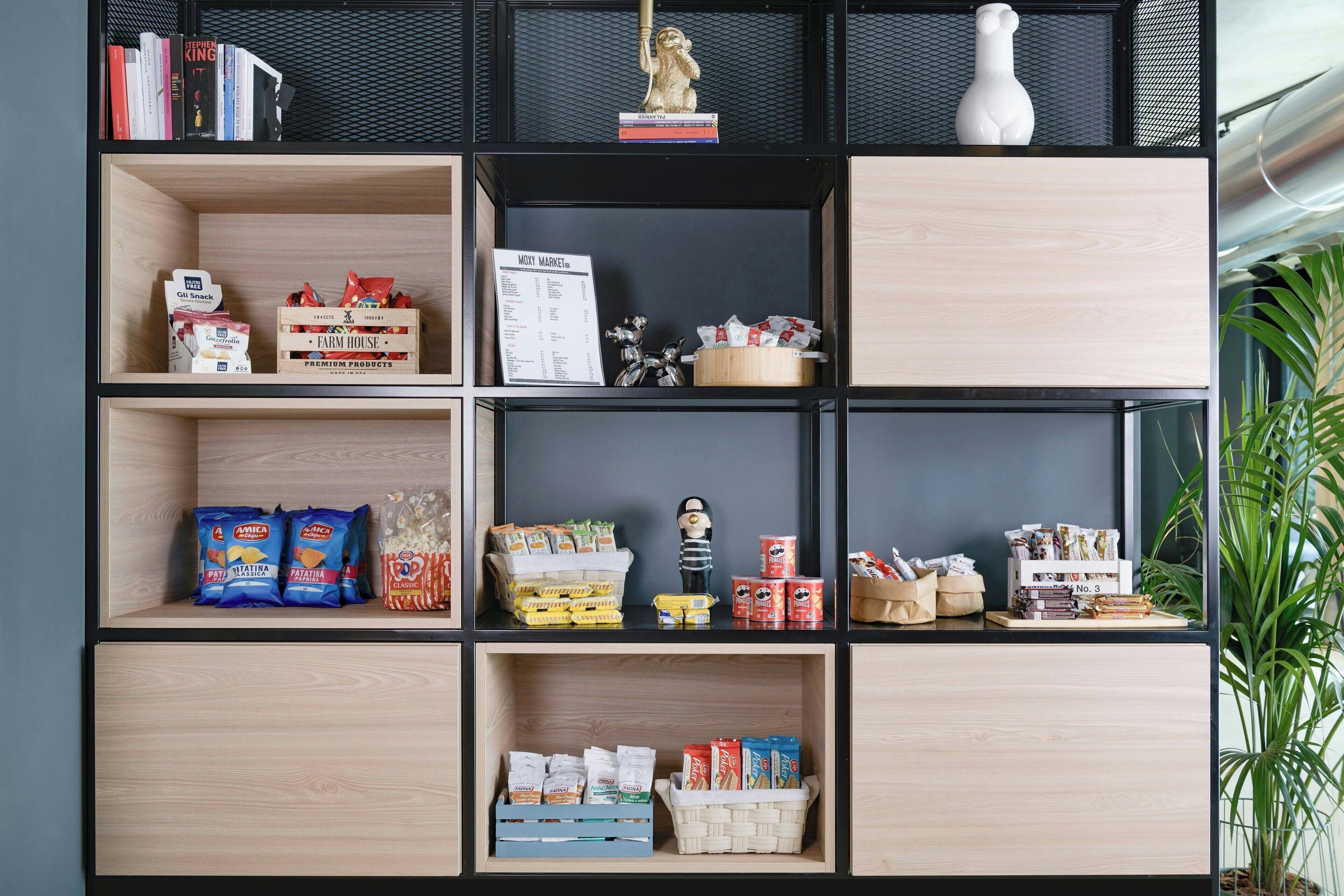 A bookshelf with various items including books, snacks, and decorative objects.