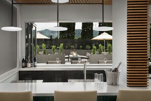 A modern outdoor dining area with a bar counter, seating, and a view of a mountainous landscape. - Fairfield By Marriott Inn & Suites Portland Newberg (Newberg)