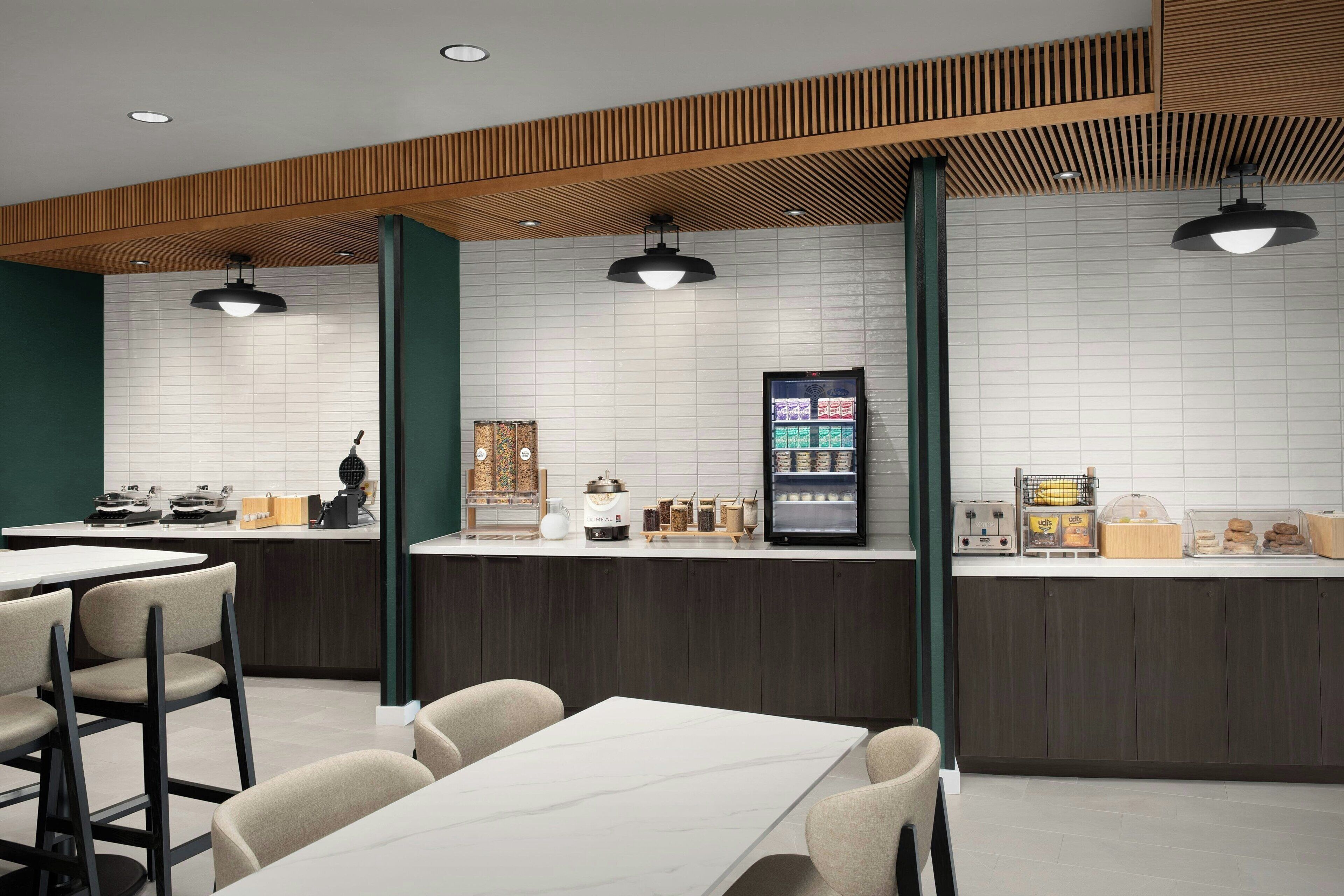 Un café moderno con mostrador, zona de asientos y una máquina de café.