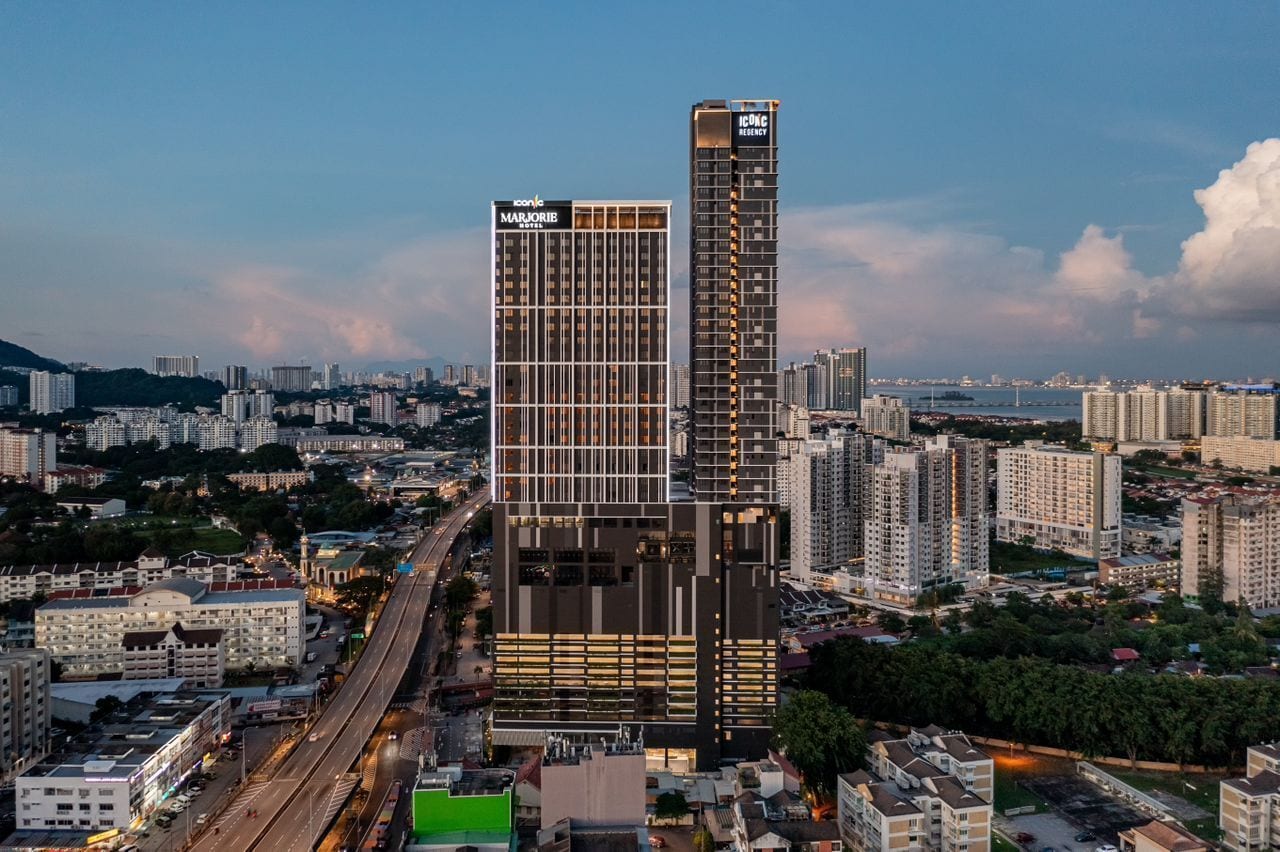 A high-rise building with a modern design, featuring a prominent logo on the facade.