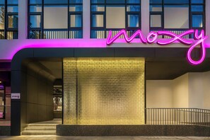 A modern building with a neon sign reading "moxy" and a textured glass wall. - Moxy Suzhou City Centre (Suzhou)