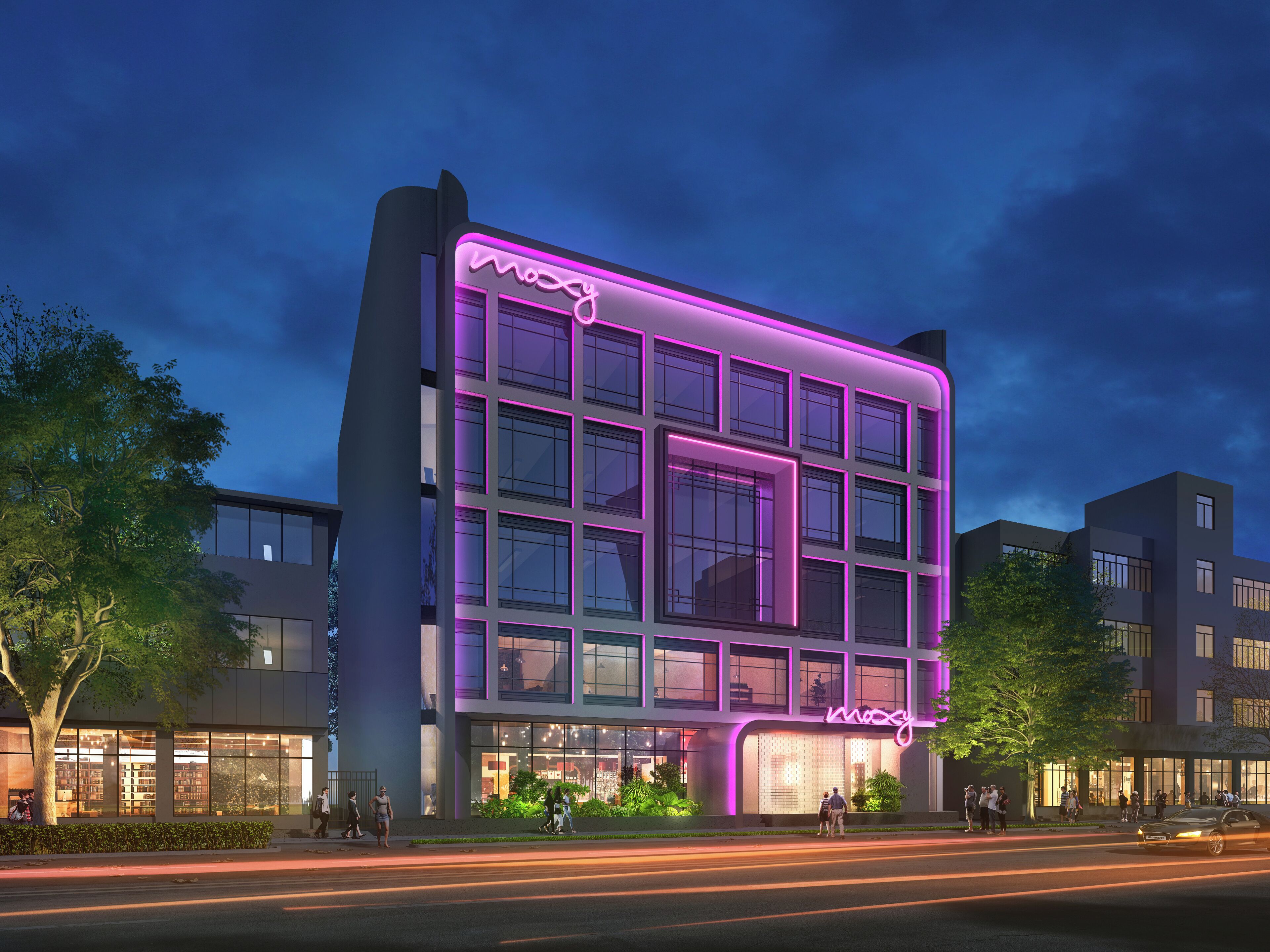 Un edificio moderno con un'insegna al neon, ampie vetrate e un ingresso ben illuminato.