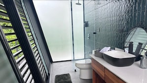 Une salle de bain moderne avec une grande fenêtre, un lavabo blanc et un meuble-lavabo en bois.