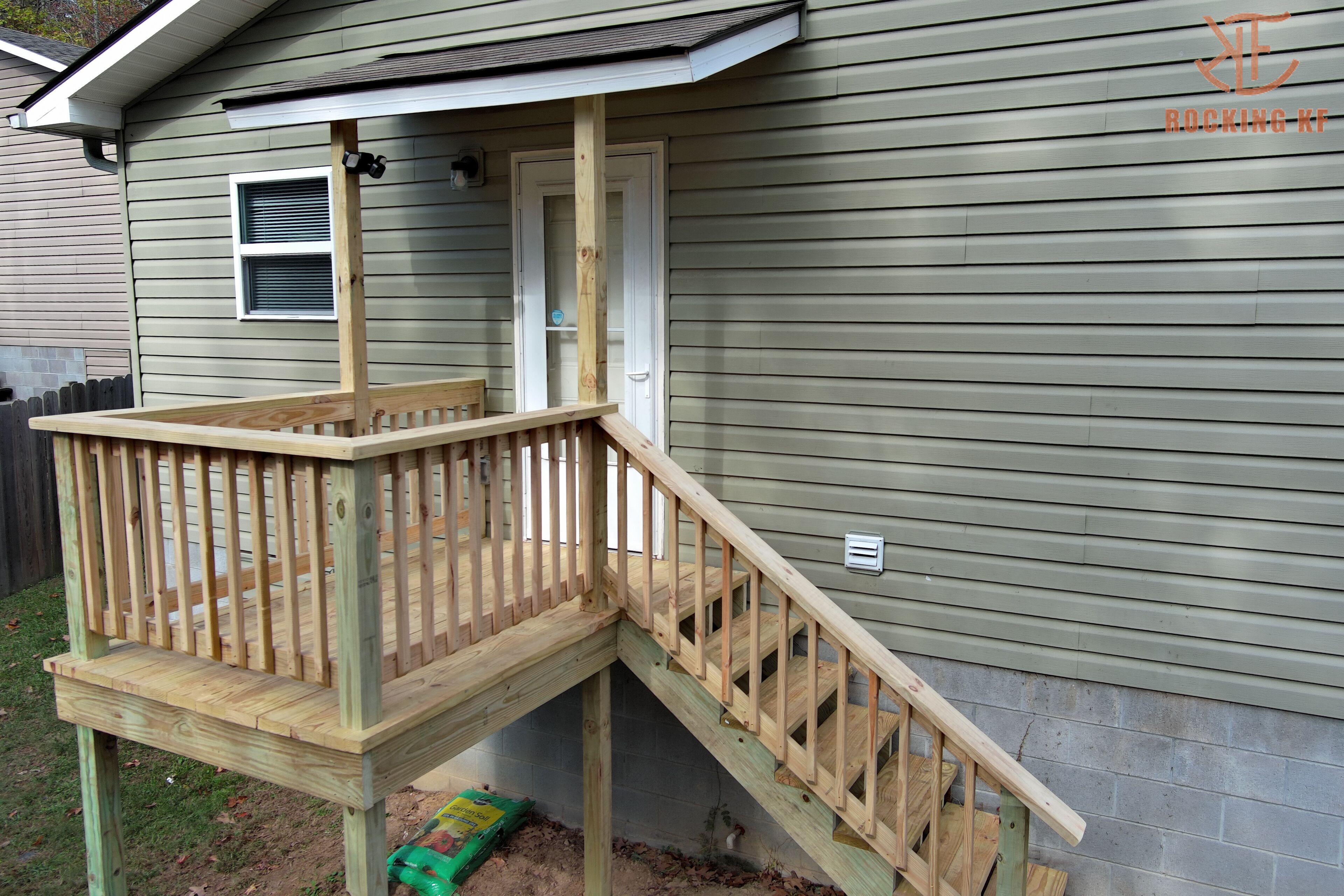 A wooden deck with a staircase leading to a house.