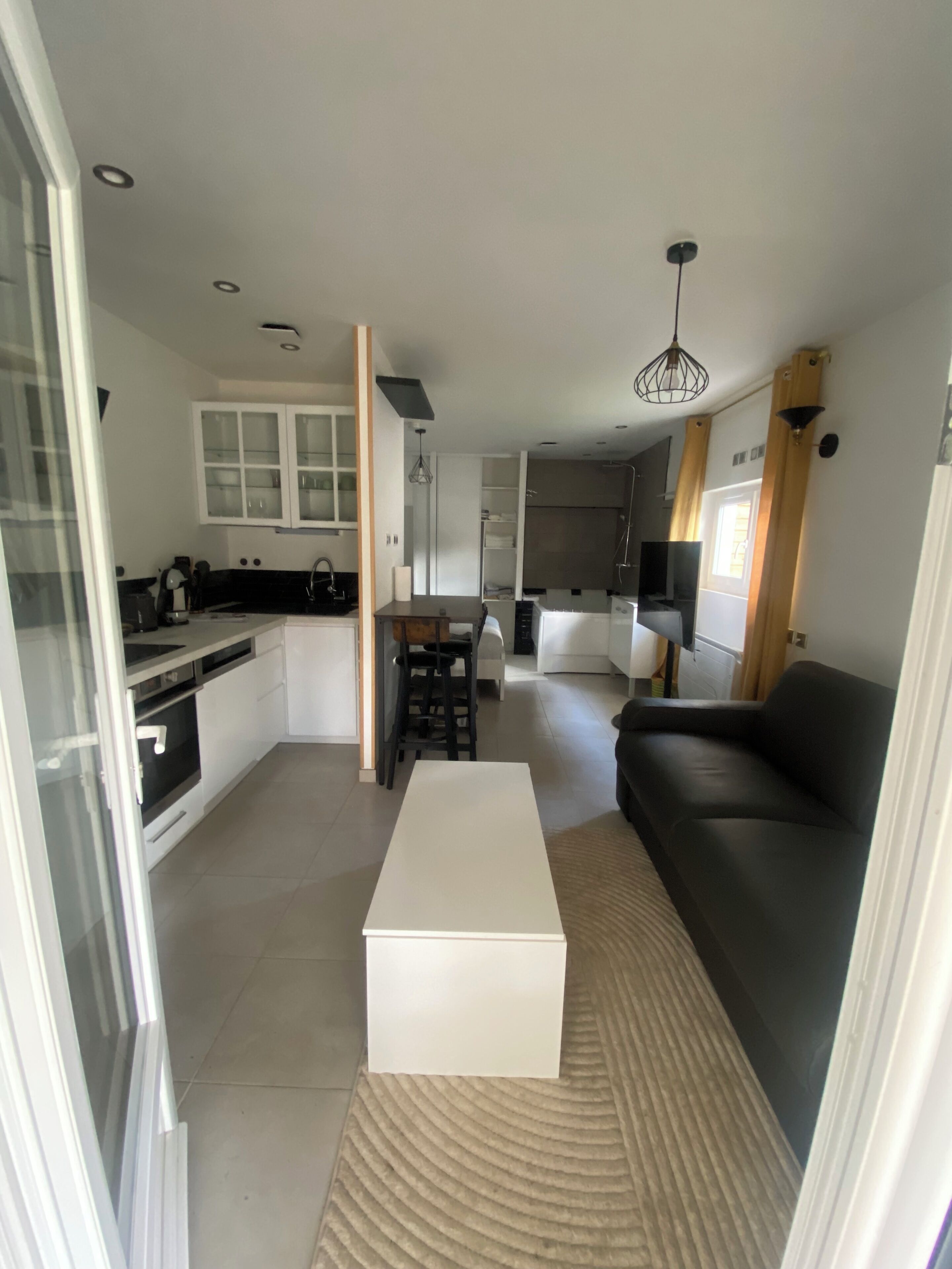 A modern apartment with a kitchen, dining area, and living room.