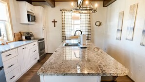 A kitchen with white cabinets, a granite countertop, a stainless steel sink, and a wooden ceiling. - Perfect Family Cabin! 3 Master Suites, Sleeps 10, next to the park! (South Fork)