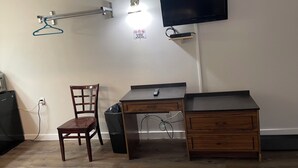 A room with a desk, chair, TV, and a wall-mounted shelf. - Niton Junction Motel (Niton Junction)