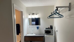 A compact bathroom with a toilet, sink, mirror, and a microwave. - Niton Junction Motel (Niton Junction)
