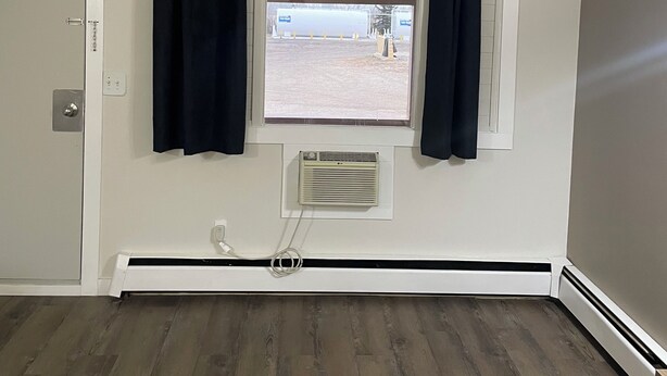 A room with a window, a radiator, and a door. - Niton Junction Motel (Niton Junction)