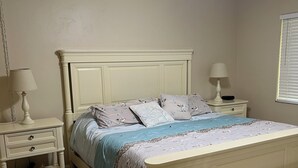 A bedroom with a bed, two bedside tables, a ceiling fan, and a window with blinds. - Chic 2-bedroom condo with AC, WiFi in Naples, Resort like pool. 3 miles to beach (Naples)