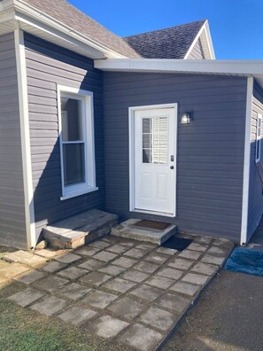 A house with a grey exterior, a white front door, and a small porch with steps leading up to it. - Chic Studio in Downtown Danville Centre, pets OK (Danville)