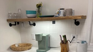 A kitchen with a washing machine, a coffee maker, and various kitchen items on the counter. - Chic luxury studio, Downtown Danville, Pets OK, Centre College & Bourbon Trail  (Danville)