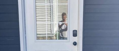 A white door with a glass panel and a keypad lock.