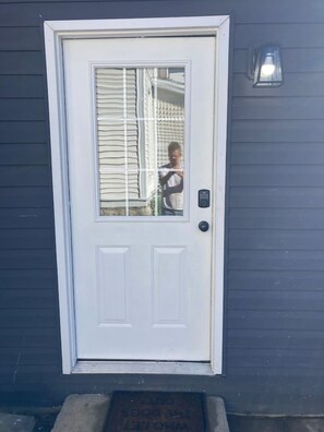 A white door with a glass panel and a keypad lock. - Chic Studio in Downtown Danville Centre, pets OK (Danville)
