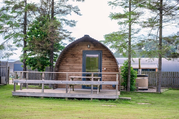 Une cabane en bois avec une véranda et une porte.