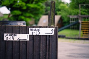 Uma placa de sinalização com setas indicando 'MILLSIDE 1-10' e 'BARNSIDE 11-19'.