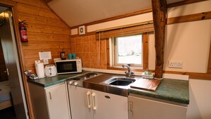 A compact kitchen with a microwave, toaster, and sink. - Rustic Log Cabin With Hot Tub (Kinloss)