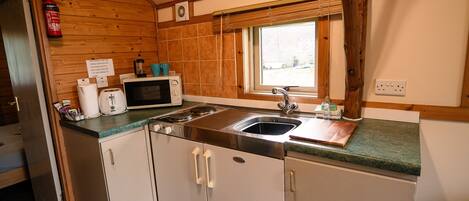 A compact kitchen with a microwave, toaster, and sink.