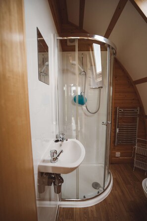 A modern bathroom with a glass-enclosed shower, a white sink, and wooden beams on the ceiling. - Romantic Cosy Glamping Cabin With Luv Tub (Llanbrynmair)