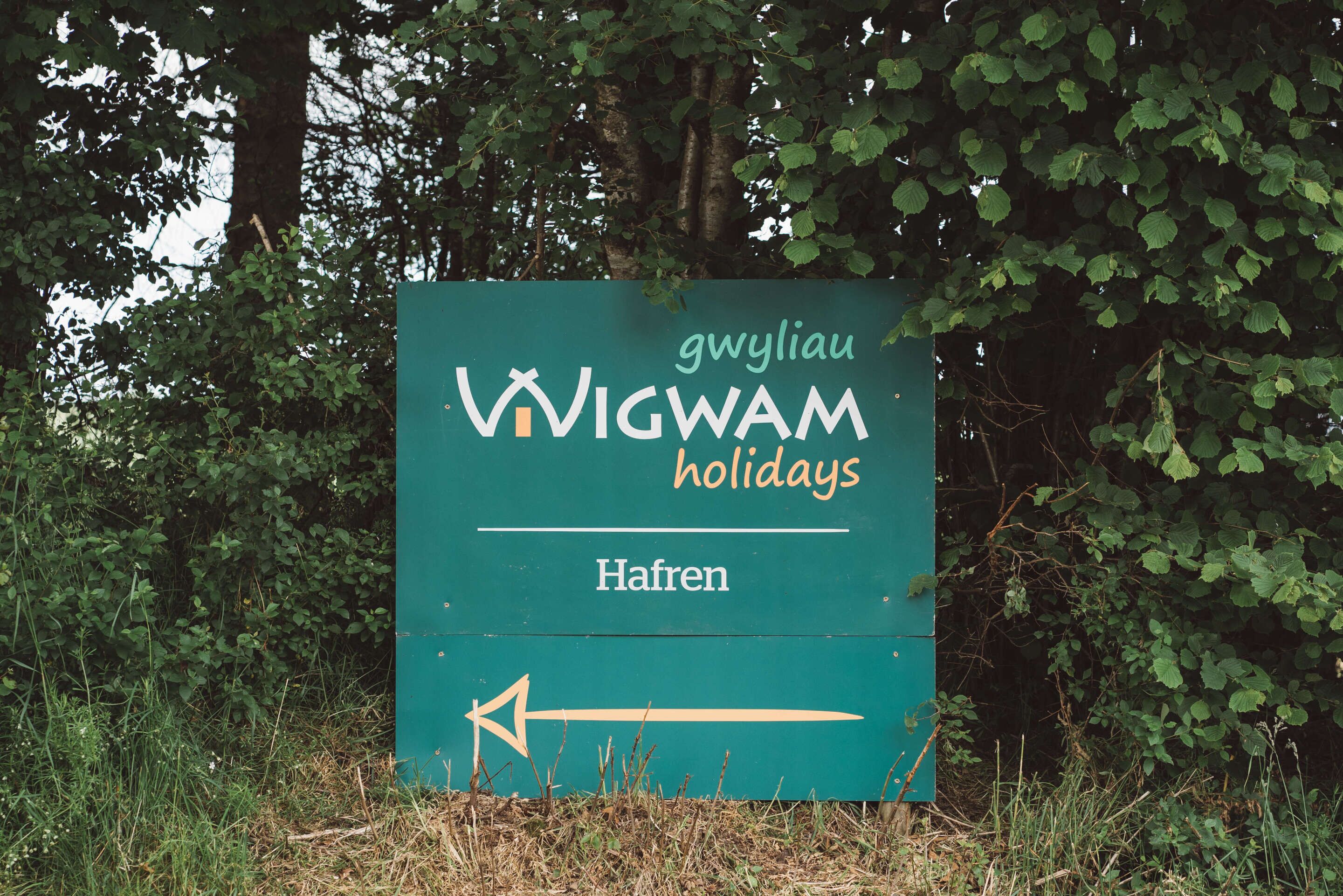 A sign for 'VIGWAM holidays' with a directional arrow pointing left.