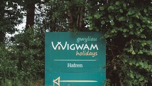 A sign for 'VIGWAM holidays' with a directional arrow pointing left.