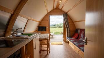 A cozy, wooden interior with a kitchen, dining area, and a sofa.