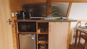 A compact kitchenette with a refrigerator, microwave, and sink. - Rural Cabin in the Welsh Countryside (Llanbrynmair)