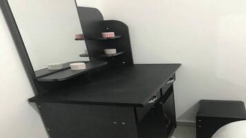 A black desk with a mirror, shelves, and storage compartments.