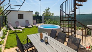 A backyard with a pool, a small white building, and a spiral staircase. - Villa in Galizana With Bubble Bath (Vodnjan)