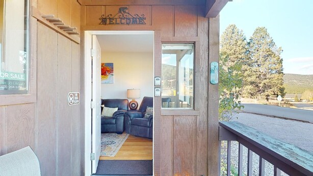Une façade en bois avec une pancarte « BIENVENUE », une autre indiquant « PAS D’ANIMAUX DOMESTIQUES » et une troisième, sur la vitrine, annonçant « À VENDRE ».