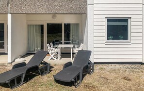 A house with a covered patio, outdoor seating, and a window. - 1 bedroom amazing apartment in Nexø (Nexø)