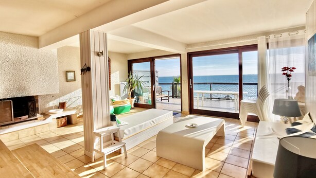 A spacious living area with a fireplace, a sofa, a coffee table, and a balcony with a view of the sea. - Seaside apartment - Cap Ferret - Bassin d' Arcachon (Lège-Cap-Ferret)