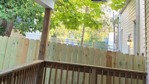 A covered outdoor area with a ceiling fan and a wooden deck. - Charming 2-bedroom house in close proximity to the YUM Ctr, the Downs, etc. (Louisville)