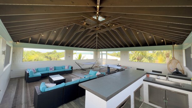 A spacious living area with a large sofa, a dining table, and a kitchen area.