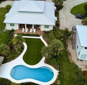 A two-story house with a swimming pool, a covered patio, and a well-maintained lawn. - Indian River Retreat - Main House and Cottage (Jensen Beach)