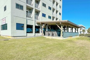 Un edificio de varios pisos con una zona de estar al aire libre cubierta y un letrero de restaurante.