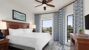 A hotel room with a large bed, two bedside tables, a ceiling fan, and patterned curtains. - arriott Harbour Point 2025 PGA Tour RBC Heritage Week - 2 Bd, 2 Bath Villa (Hilton Head)
