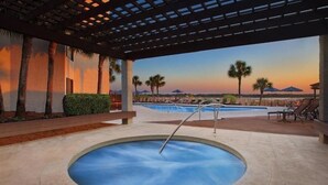 A hot tub area with a view of a pool and palm trees at sunset. - arriott Harbour Point 2025 PGA Tour RBC Heritage Week - 2 Bd, 2 Bath Villa (Hilton Head)