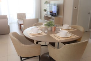 A dining area with a round table set for four, surrounded by four chairs. - Ocean View Apt on the Beach 2 Bedroom 2 Bath. (Hollywood)