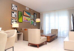 A modern living room with a sofa, armchairs, a coffee table, and artwork on the walls.
