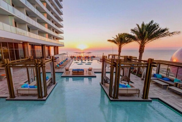 A rooftop pool with sun loungers and a view of the sunset over the ocean. - Ocean View Apt on the Beach 2 Bedroom 2 Bath. (Hollywood)