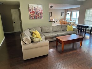 Ein Wohnzimmer mit Sofa, Couchtisch und Kunstwerk an der Wand.