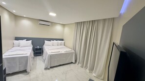 Deluxe Triple Room | Desk, laptop workspace, blackout drapes, iron/ironing board