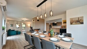 Un comedor moderno con una mesa larga dispuesta para seis comensales, rodeada de seis sillas.