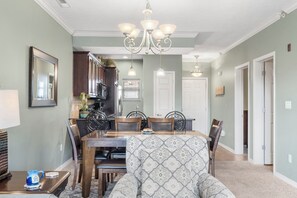 A dining area with a table, chairs, and a chandelier. - Wooded View 2-Bedroom Condo with Deck, Free Tickets & Close to State Park Marina (Branson)