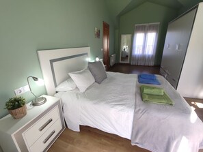 A bedroom with a bed, bedside table, lamp, and a wardrobe.